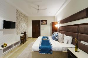 a bedroom with a large bed and a desk at Sonam Plaza in Ludhiana