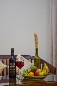 une table avec une assiette de fruits et un verre de vin dans l'établissement Sonam Plaza, à Ludhiana