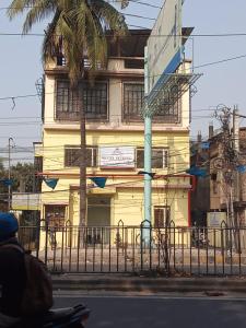 HOTEL SKYKING في Gauripur: شخص يركب سكوتر أمام المبنى