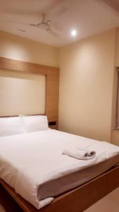 a bedroom with a large bed with white sheets at HOTEL SKYKING in Gauripur