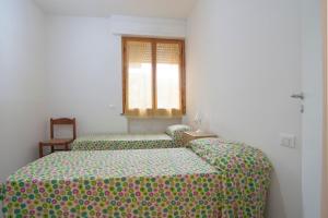 2 Einzelbetten in einem Zimmer mit Fenster in der Unterkunft Appartamento Prato in Follonica
