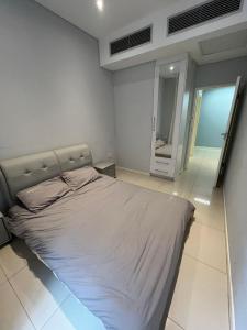 a large bed in a bedroom with a mirror at Room 50Two, Itower Apartment, CBD, Gaborone in Gaborone