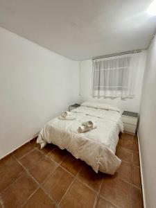 um quarto com uma cama num quarto branco em Casa Puebla Arenoso I Rental Holidays REF. 064 em Puebla de Arenoso