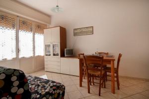 a room with a table and chairs and a kitchen at Appartamento NAS in Follonica