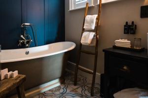 a bathroom with a tub and a ladder in it at Regency House in Belfast