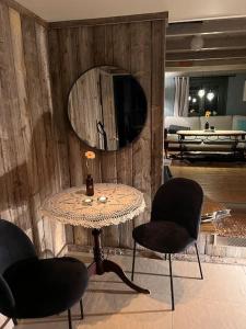 een kamer met een tafel, 2 stoelen en een spiegel bij Stabbur med fantastisk utsikt! in Steinkjer
