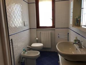 a bathroom with a toilet and a sink at Appartamento FAB in Follonica +14 photos