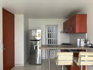 uma cozinha com um frigorífico de aço inoxidável e armários de madeira em Apartamento con excelentes comodidades em Cúcuta