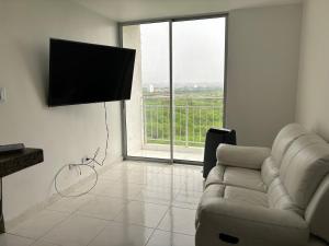 uma sala de estar com um sofá e uma televisão de ecrã plano em Apartamento con excelentes comodidades em Cúcuta