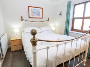 - une chambre avec un lit blanc et une fenêtre dans l'établissement Elder Cottage, à Richmond