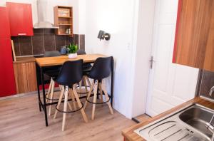 a kitchen with a wooden table and black chairs at Cosy Castle Flat in Ljubljana Center - FREE PARKING in Ljubljana