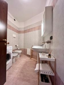 a bathroom with a sink and a toilet and a washing machine at Perla Apartment Verona in Verona