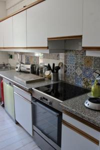 a kitchen with white cabinets and a stove top oven at Appartement Parc in Saint-Gervais-les-Bains