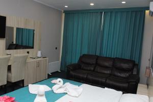 a hotel room with a couch and towels on a bed at Altyn Shatyr Hotel and Restaurant in Aksay +91 photos