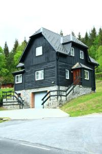 維爾布諾波布拉甸登的住宿－Horská vila Heda，山丘上带车道的大型黑色房屋