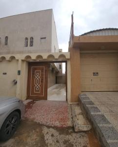 una casa con un coche aparcado frente a un garaje en رهف ريزيدنس Rahaf smart residence en Riad