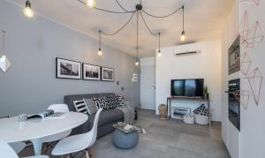 ein Wohnzimmer mit einer Couch, einem Tisch und einem Fernseher in der Unterkunft [PORTO CERVO]Incantevole Vista sul Golfo del Pevero in Abbiadori