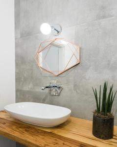 ein Badezimmer mit einem Waschbecken und einem Spiegel auf einer Ablage in der Unterkunft [PORTO CERVO]Incantevole Vista sul Golfo del Pevero in Abbiadori + 7 Fotos