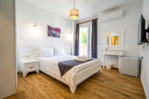 um quarto branco com uma cama e uma secretária em LONDİA OTEL em Alacati