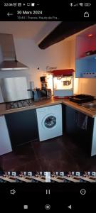 a kitchen with a stove and a washing machine at L'immortel spa 2 in Cauchy-à-la-Tour