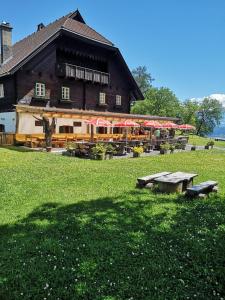 um edifício com mesas e guarda-chuvas à sua frente em Landgasthof Marhube em Baldramsdorf