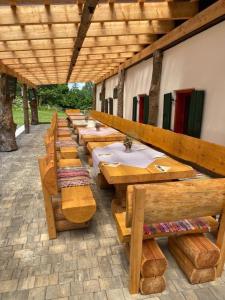 a row of wooden tables and benches in a building at Landgasthof Marhube in Baldramsdorf