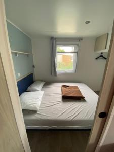Habitación pequeña con cama y ventana en Mobil home - Clim, TV - Camping Falaise Narbonne Plage 4 étoiles - 010, en Narbonne-Plage