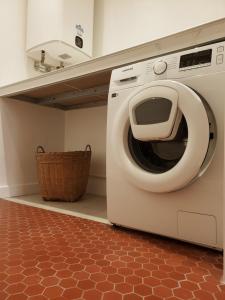 een wasmachine in een keuken met een mand bij Gîte de charme XIXe in Grand-Champ