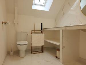 een badkamer met een toilet, een wastafel en een raam bij Gîte de charme XIXe in Grand-Champ