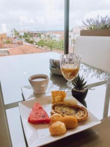 une assiette de nourriture et un verre de vin sur une table dans l'établissement HOTEL VIANA, à Barra do Corda