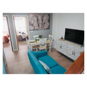 a living room with a blue couch and a television at Pontevedra Apartments - Peregrina Family Suite in Pontevedra