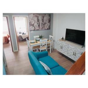 a living room with a blue couch and a television at Peregrina Blue Family Suite in Pontevedra