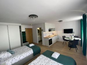 a bedroom with two beds and a kitchen with a table at Metalowiec in Stalowa Wola