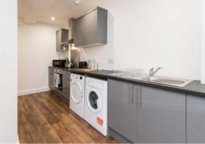 una cucina con lavatrice e asciugatrice di Webberley Stylish and Spacious Studio Unit in Stoke on Trent a Stoke on Trent