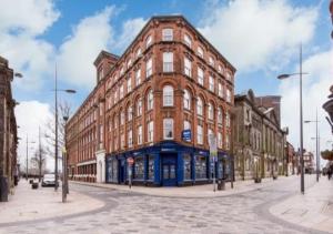 a large red brick building on a city street at Webberley Stylish and Spacious Studio Unit in Stoke on Trent in Stoke on Trent