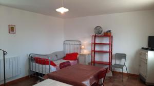 un soggiorno con letto, tavolo e sedia di Le Petit Mas des Hauts de Beyssan, Maison de vacances avec piscine privative pour 2 personnes a Gargas