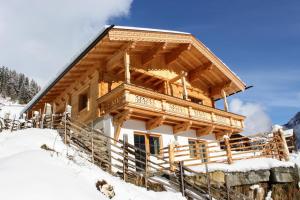 una cabaña de madera en la nieve en Ferienhaus Innerzarge, en Tux