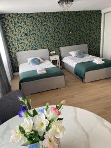 a room with two beds and a table with flowers at Metalowiec in Stalowa Wola