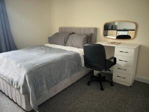 a bedroom with a bed with a desk and a chair at Studio Flat 7 With Private Shower & WC in Nottingham