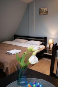 een slaapkamer met 2 bedden en een tafel met een vaas met bloemen bij Gar'is Hostel Lviv in Lviv