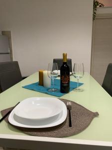 a table with a plate and a bottle of wine at Mavi house in Catania