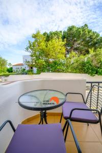 un tavolo e sedie seduti su un balcone di #094 Maresia Flats by Home Holidays ad Albufeira