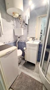 Baño blanco con lavabo y aseo en Big Base Apartment en Budapest