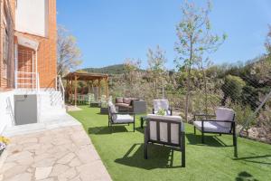 einen Garten mit Stühlen und einem Tisch auf dem Rasen in der Unterkunft Castellana in Bicorp