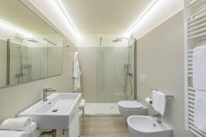 ein weißes Badezimmer mit Waschbecken und Toilette in der Unterkunft Hotel Golf Inn in Lignano Sabbiadoro + 24 Fotos