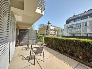 patio z 2 krzesłami i stołem oraz budynek w obiekcie Casa Marina Spa by Baltic Home w Świnoujściu