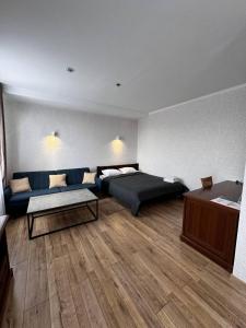 1 dormitorio con cama, sofá y mesa en Готель Elisavetgrad en Kirovograd