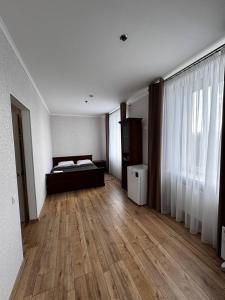 a bedroom with a bed and a wooden floor at Готель Elisavetgrad in Kropyvnytskyi