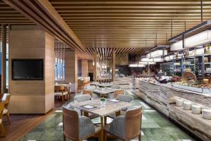 a restaurant with tables and chairs and a bar at JW Marriott Hotel Shenzhen in Shenzhen
