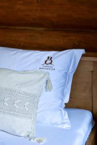 almohada blanca en una cama con cabecero de madera en Cabana Bavareză, en Porumbacu de Sus
